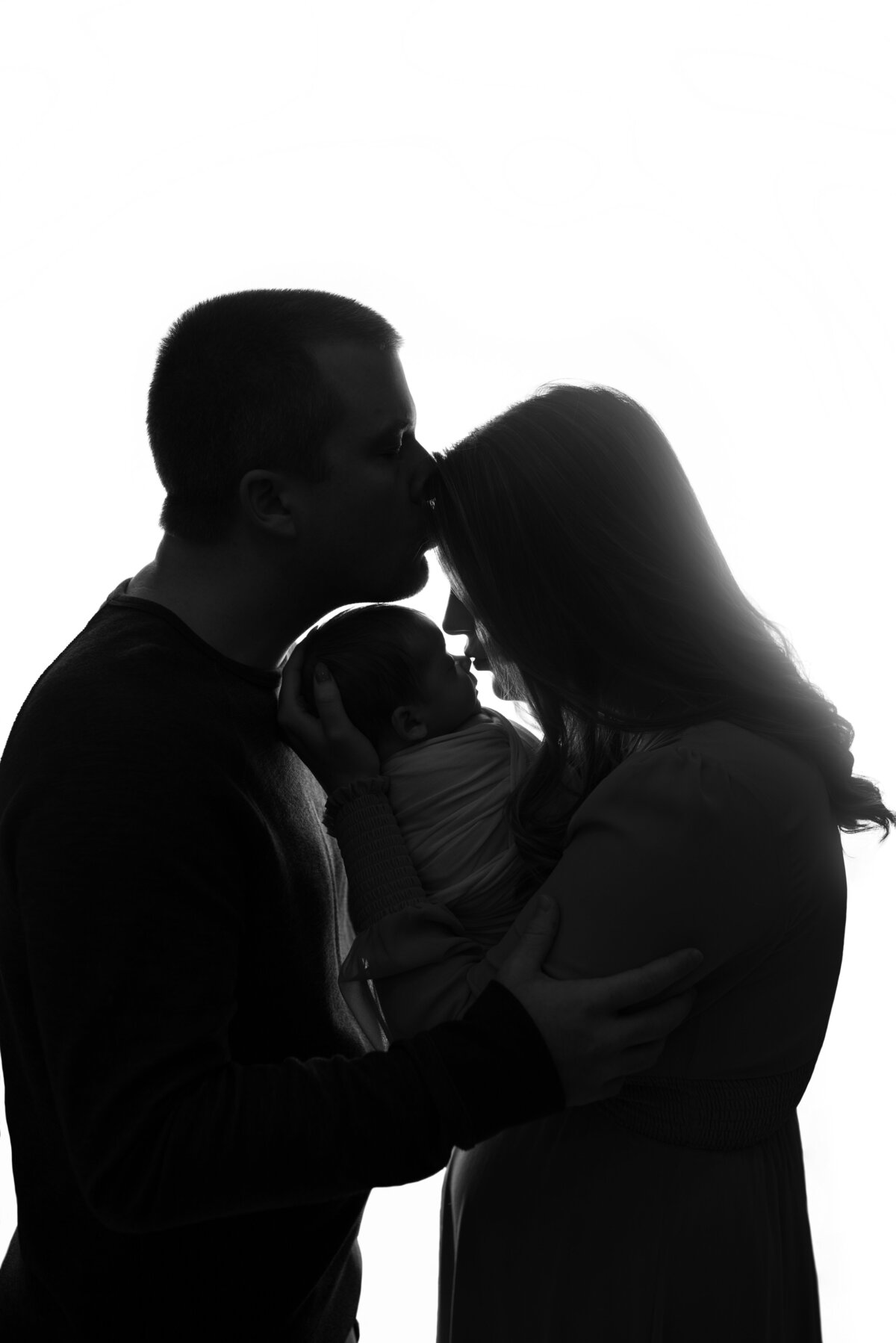 marietta ga newborn photography studio captures a silhouette image of mom, dad and newborn baby boy