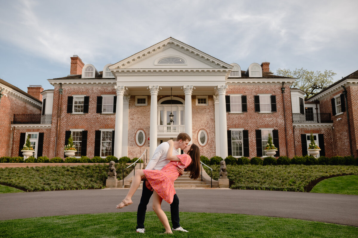 A couple dips in front of a big mansion