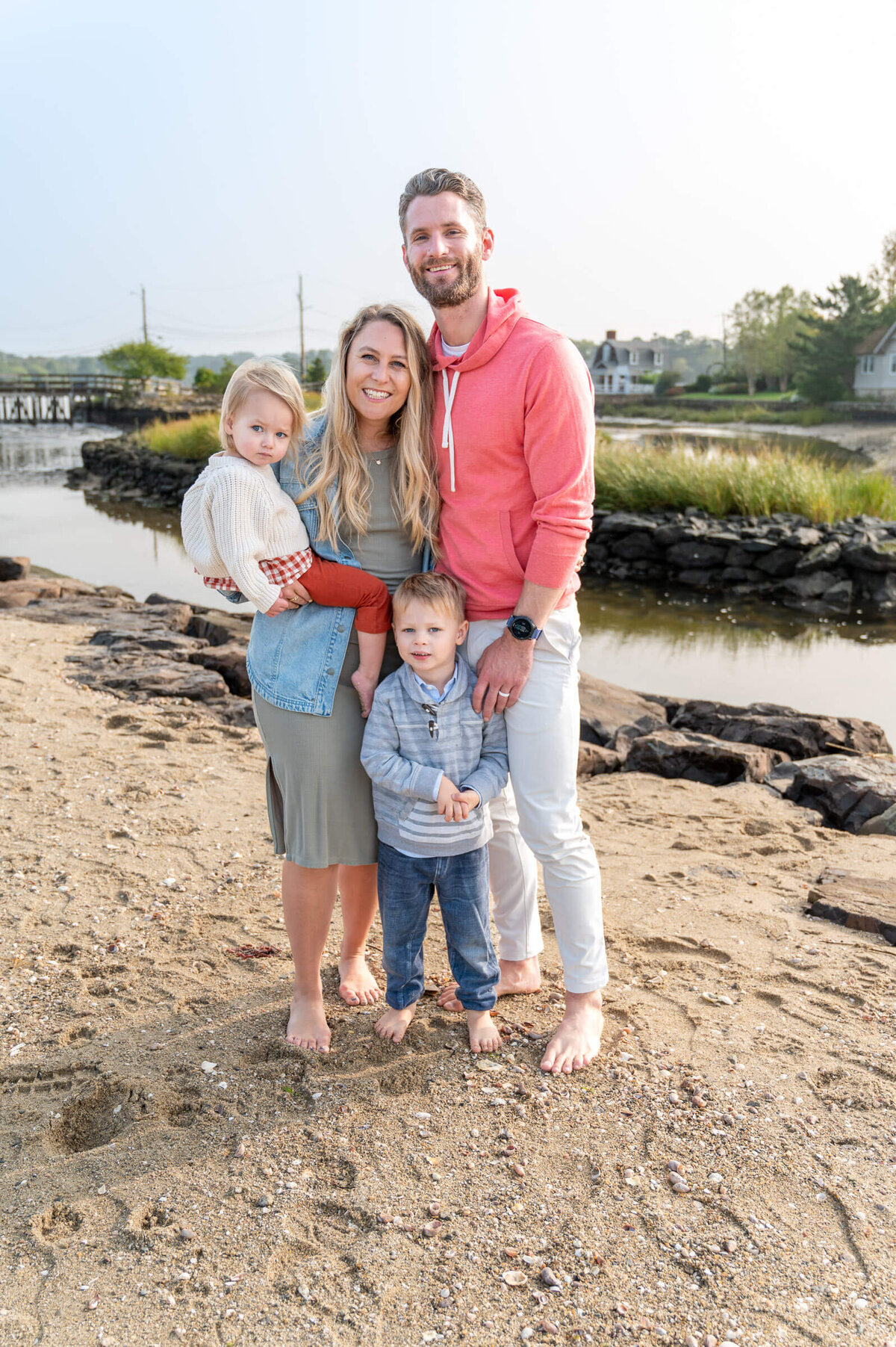 Family of four standing at Compo beach for a familly session.