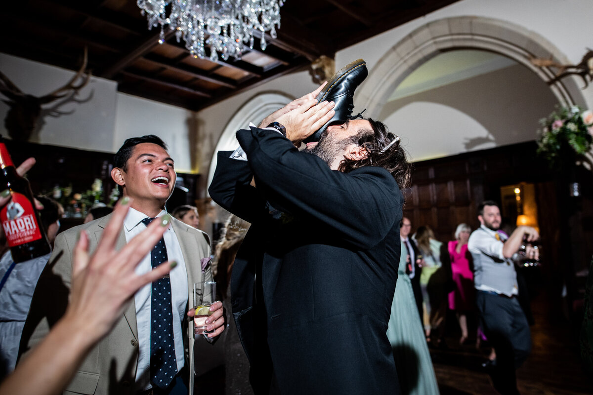 Man drinking from a shoe at wedding party
