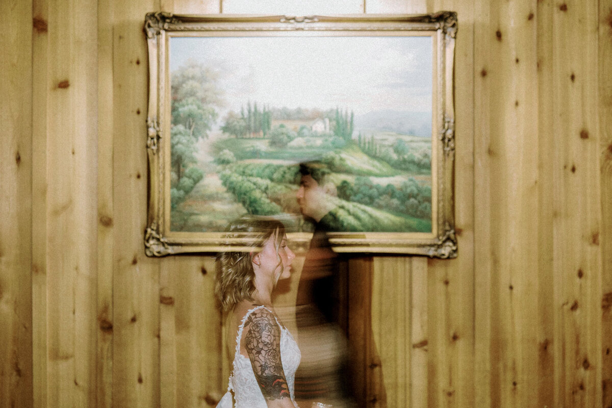Bride and Groom blur at reception work of art behind them