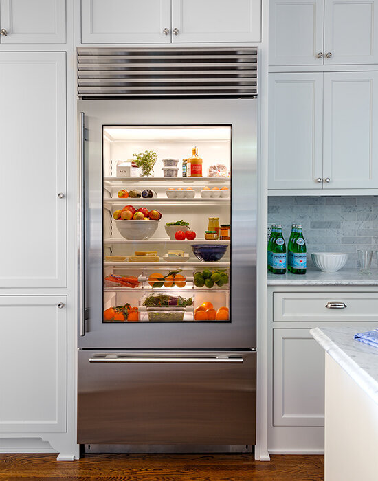 Glass-door-refridgerator-inset-among-white-cabinetry