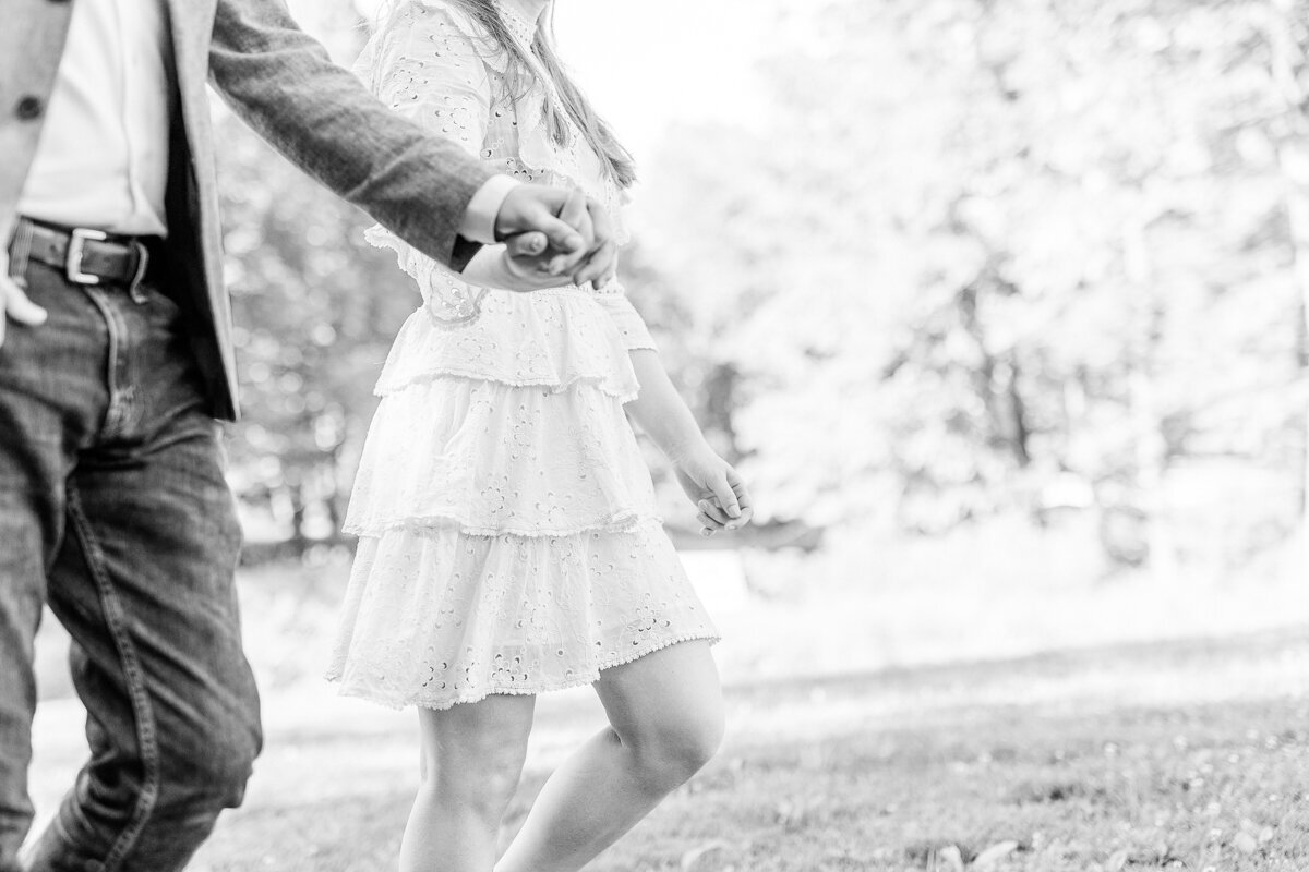 black and white photo of engaged couple holding hands.