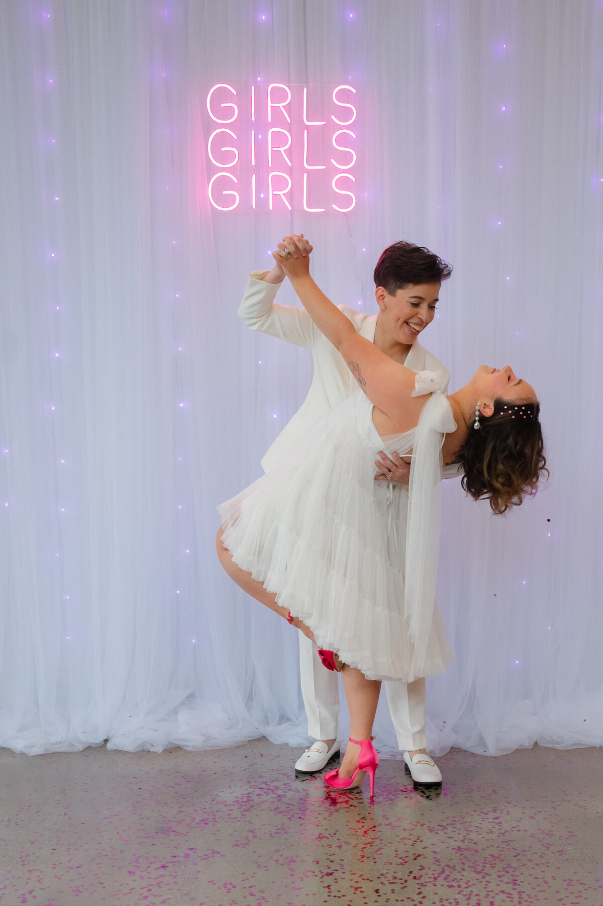 Bride dipping other bride in dance