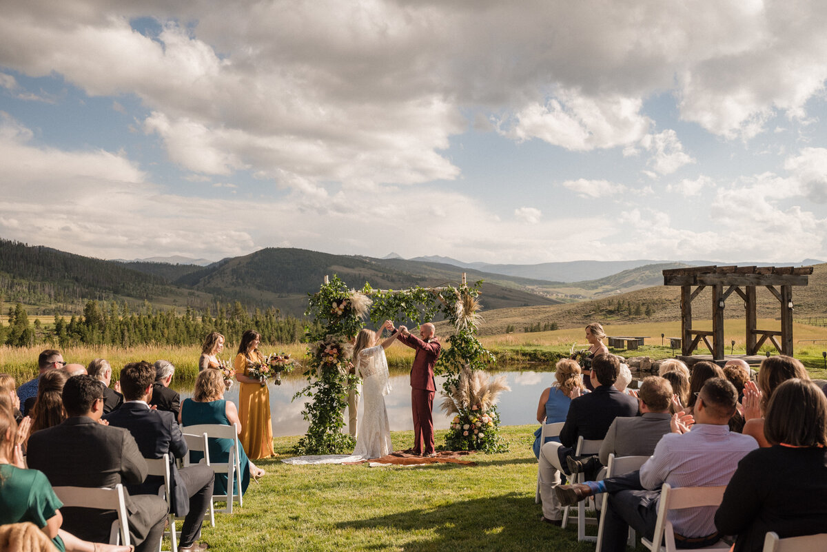 Couple celebrates during their wedding ceremony in the mountains in Colorado