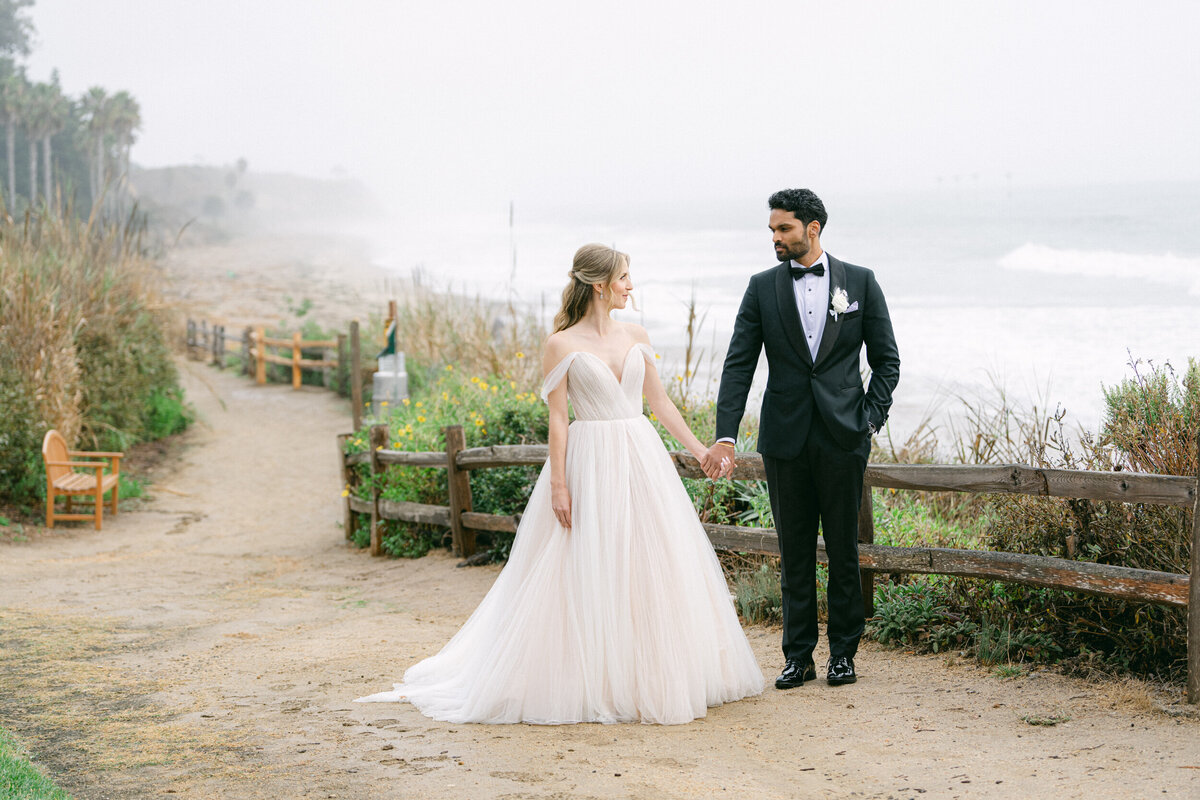 bride and groom walking holding hands on a pathway at the Bacara in Santa Barbara