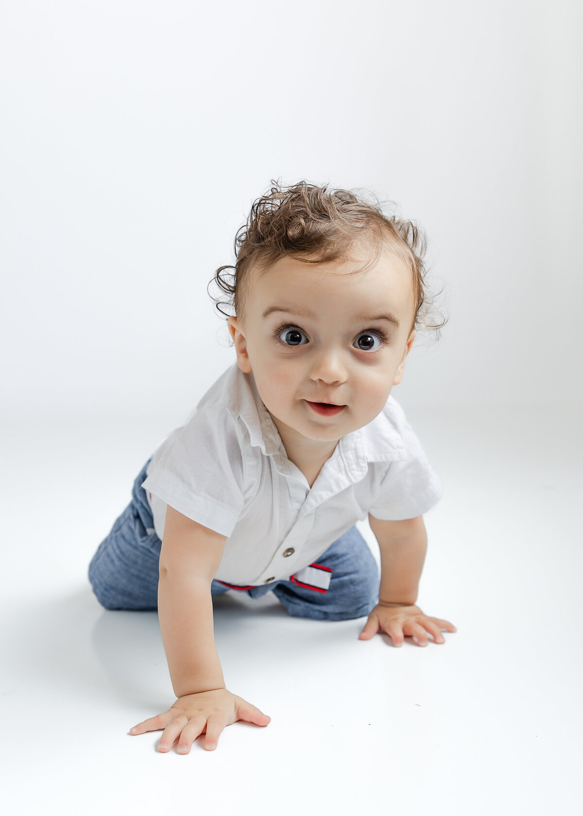 Light and airy lifestyle portrait of a baby at a 1st birthday cake smash photo session at Allison Reilly's Union County, NJ photo studio.
