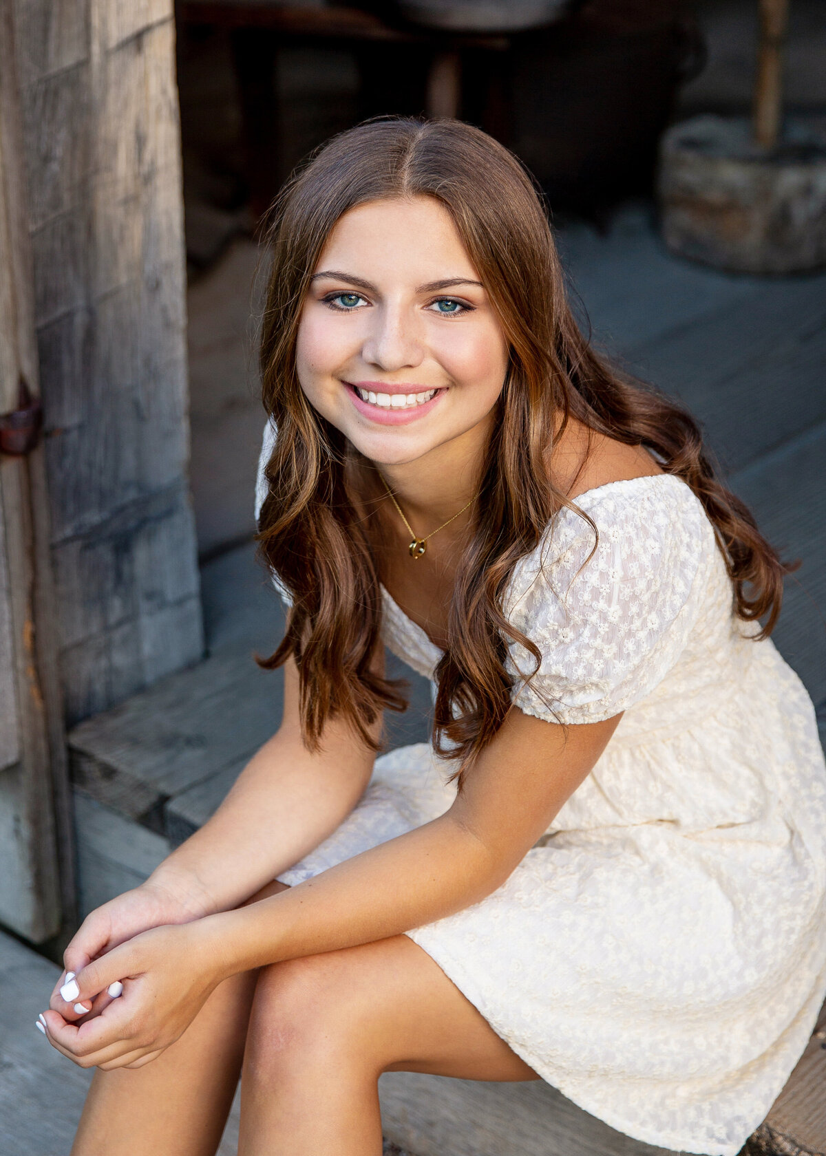 Pretty Senior pictures taken of a girl wearing a white dress from Victor, NY by a barn