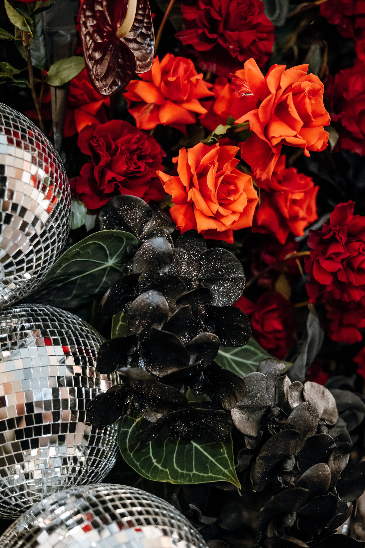 Close up shot of disco balls and red flowers at a Regal Cinema wedding.