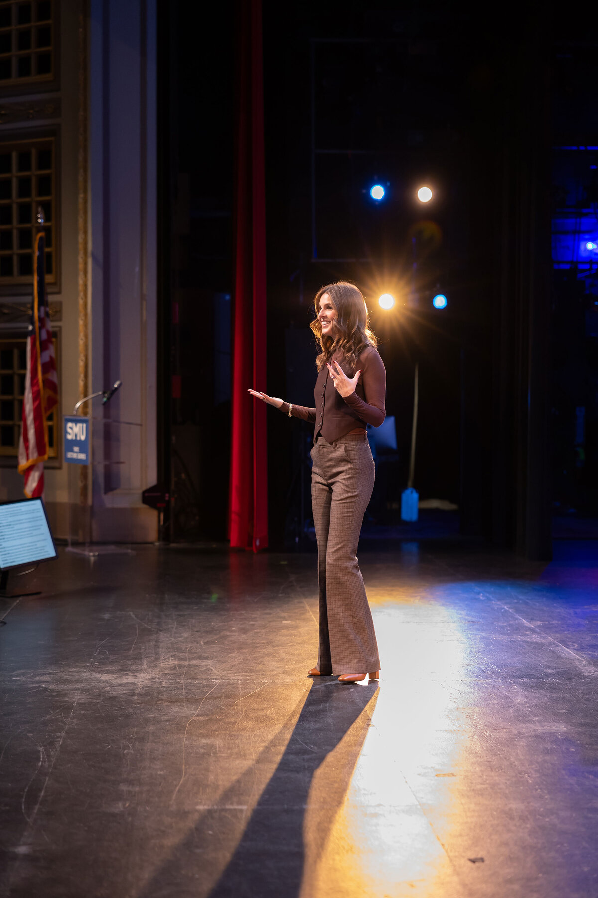 Professional brand photographer Sophie K. Hunter capturing an on-location event, featuring a powerful moment of a woman speaking on stage.