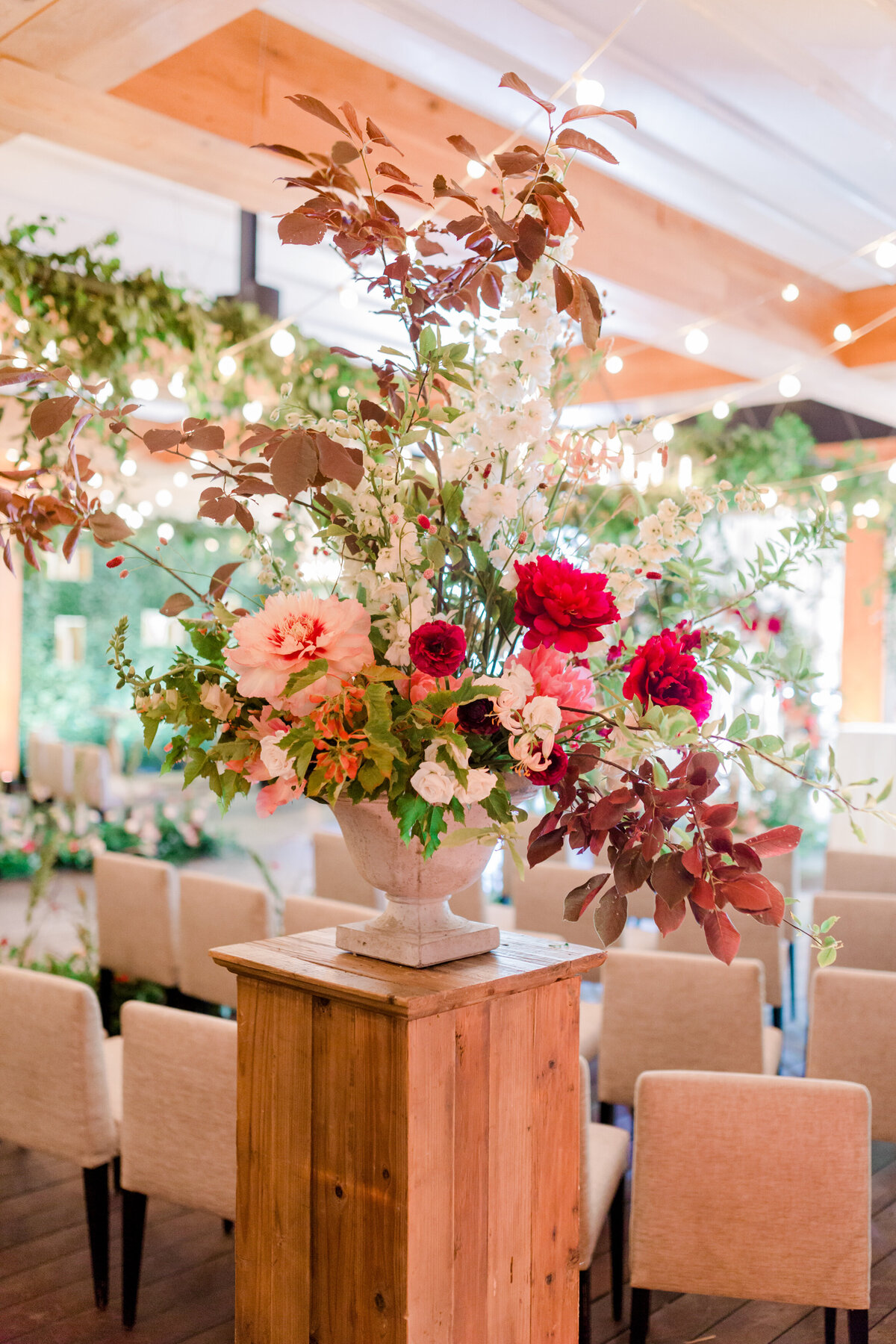 A bright floral arrangement at the start of the ceremony aisle at Restaurant Beatrice. 