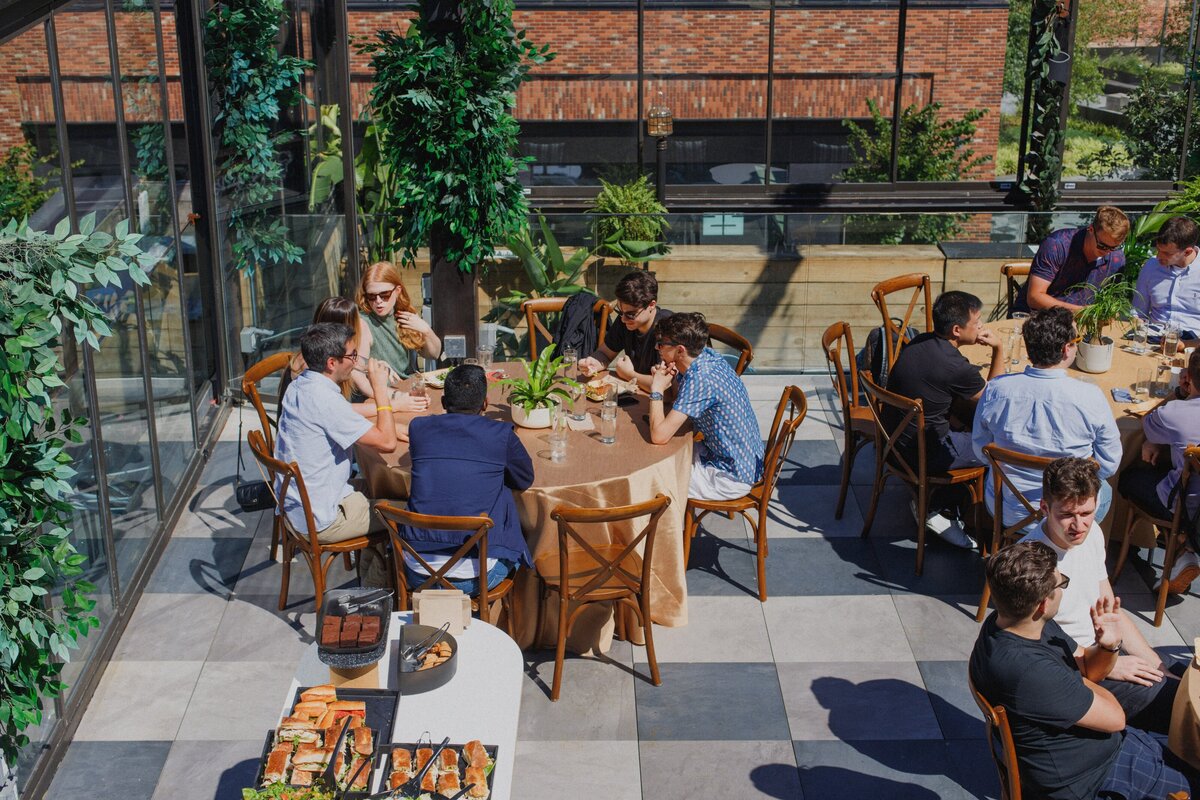 Small groups gathered around tables on the Norwood rooftop, connecting during Titan Day 3.