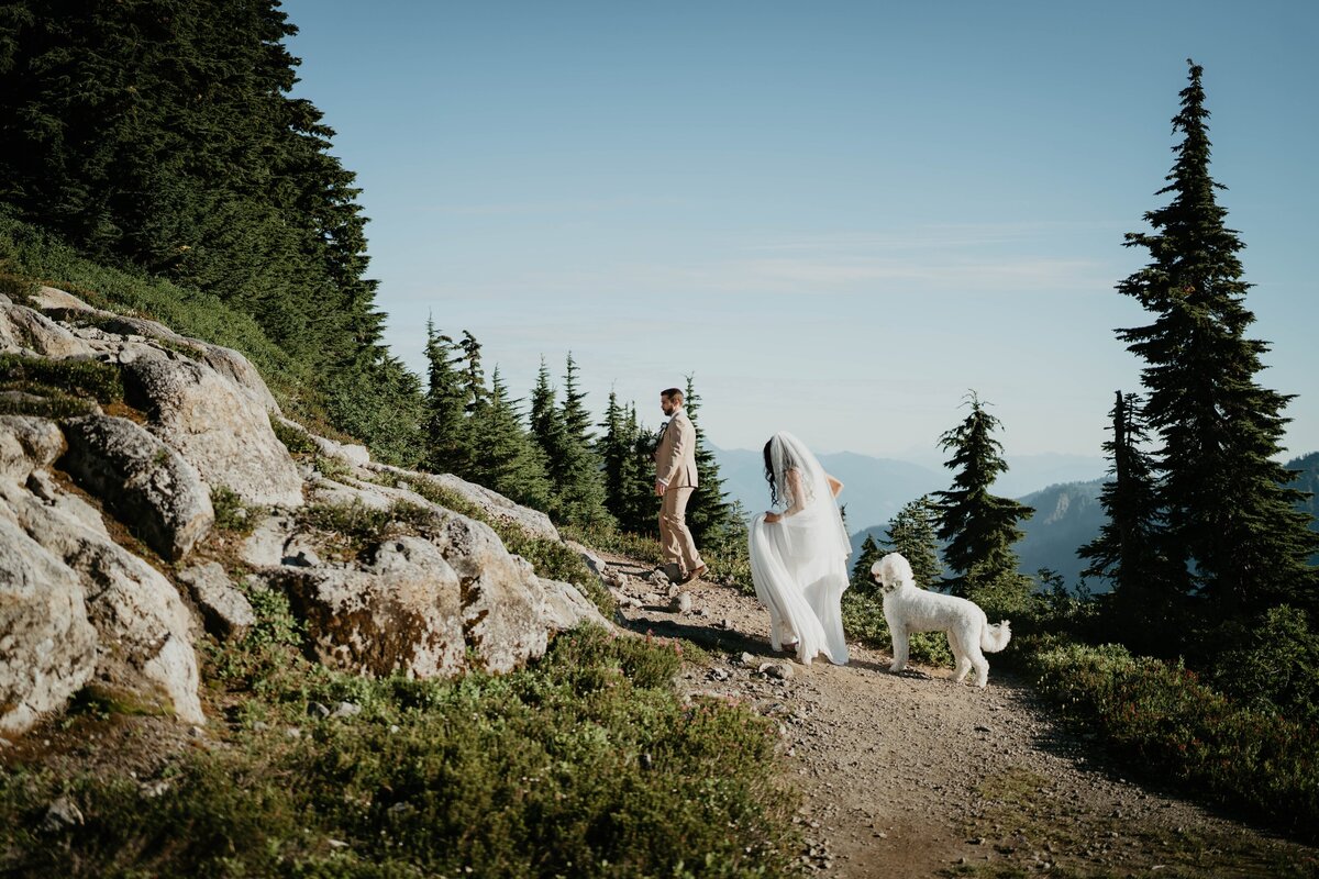 Bride and groom hiking with their dog to their elopement spot in the North Cascades