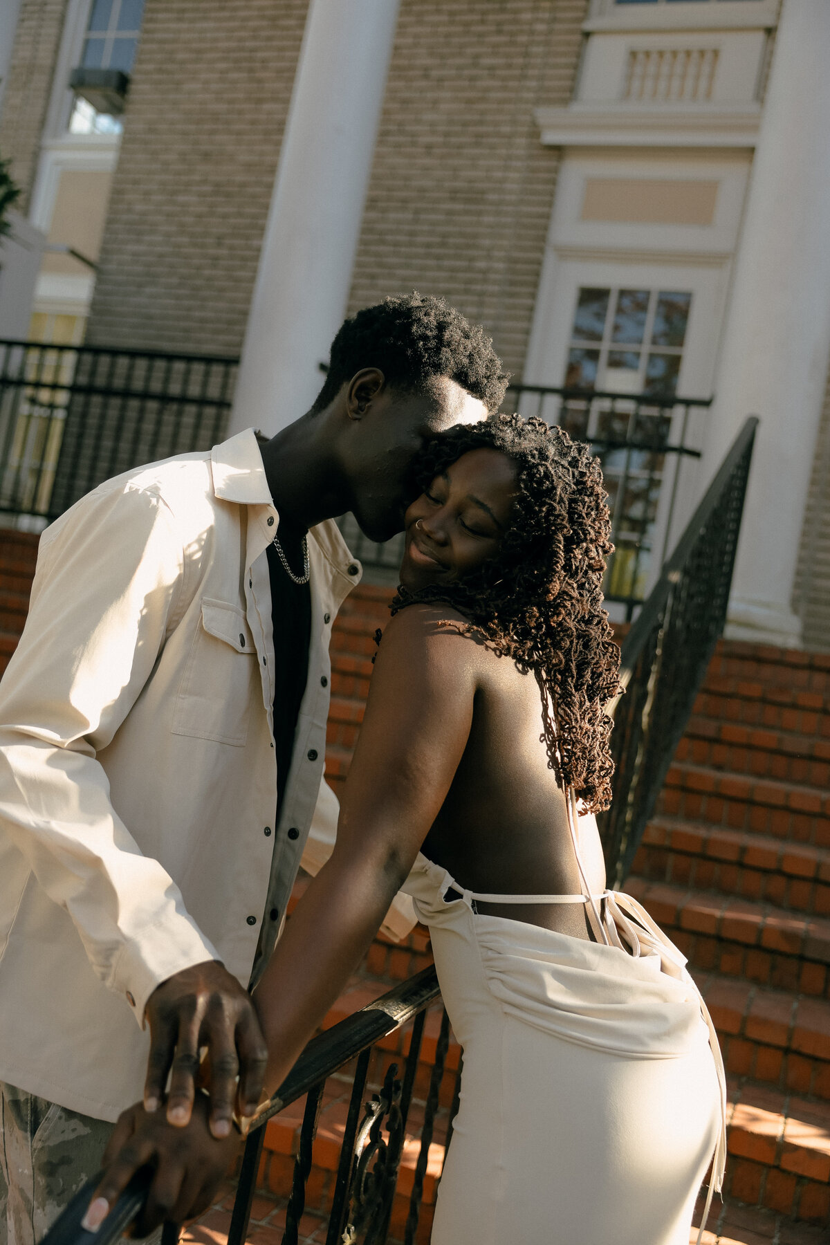 Editorial Urban Engagement Session on Brick Stairs with Playful Couple Kiss