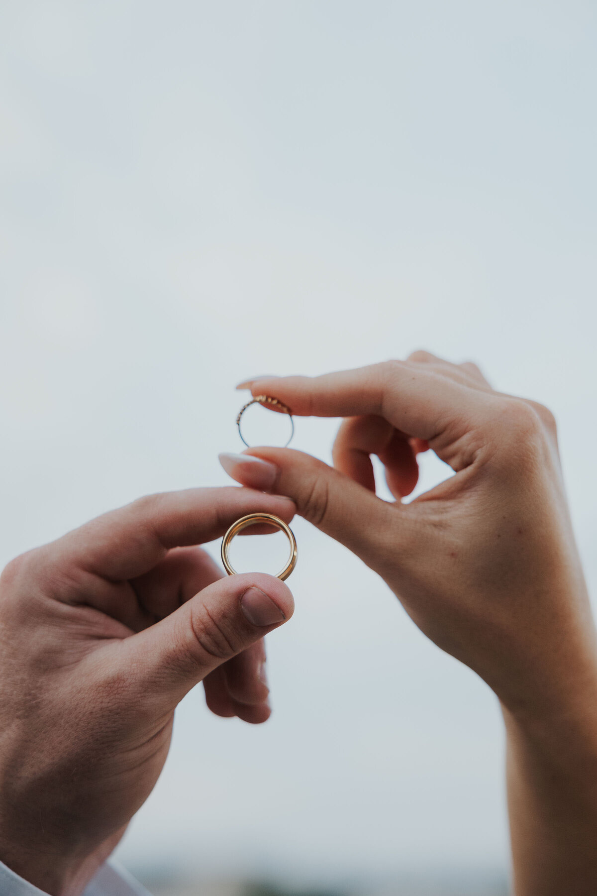detal of couple holding rings