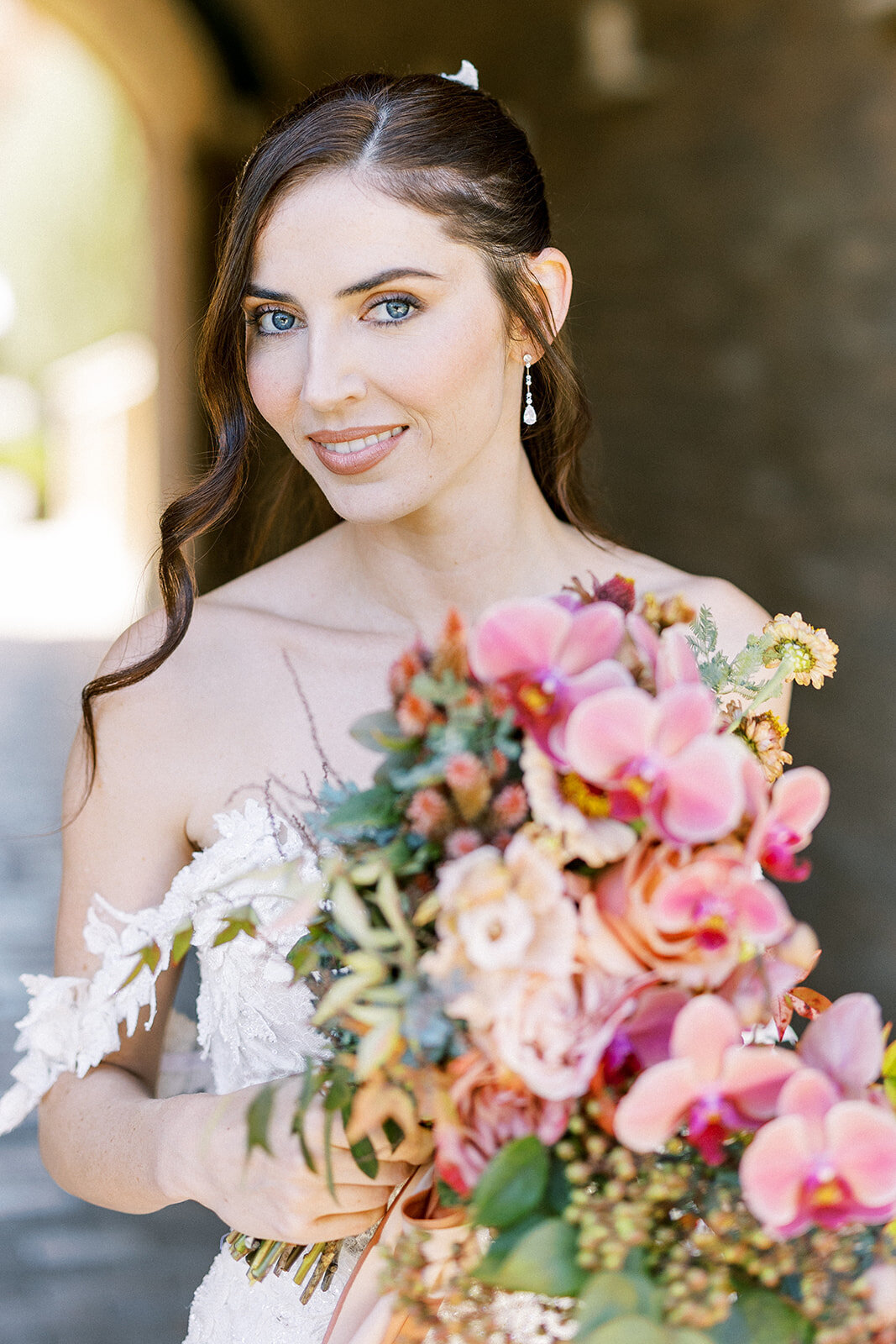 Radiant bride with a cascading bouquet of orchids and garden roses—soft, romantic, and full of bridal glow.