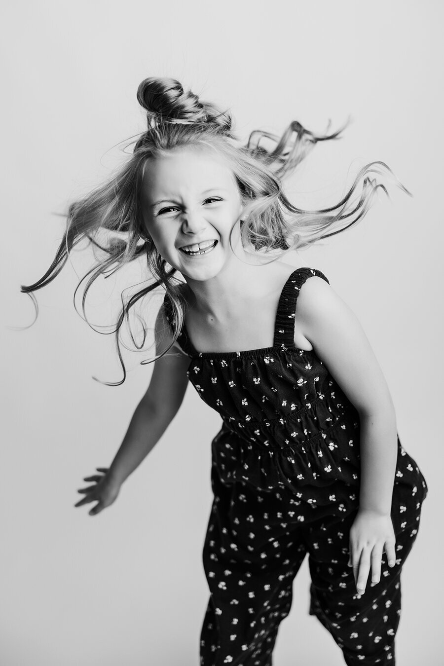 Fort Collins girl jumping with her hair crazy and laughing in black and white photo