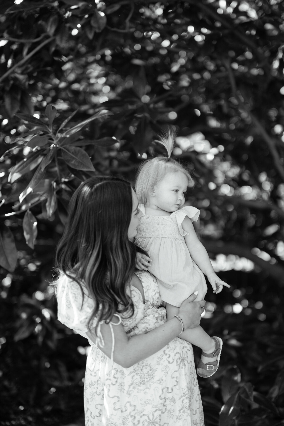 family maternity photos at the fort worth botanic garden, mom holds young daughter 