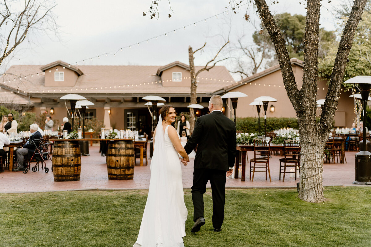 newlyweds walk into outdoor reception