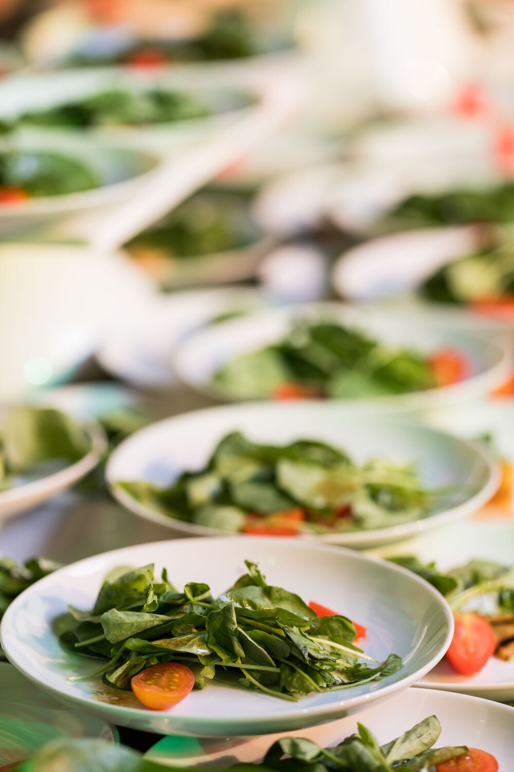 Plates of fresh salad being prepared for service