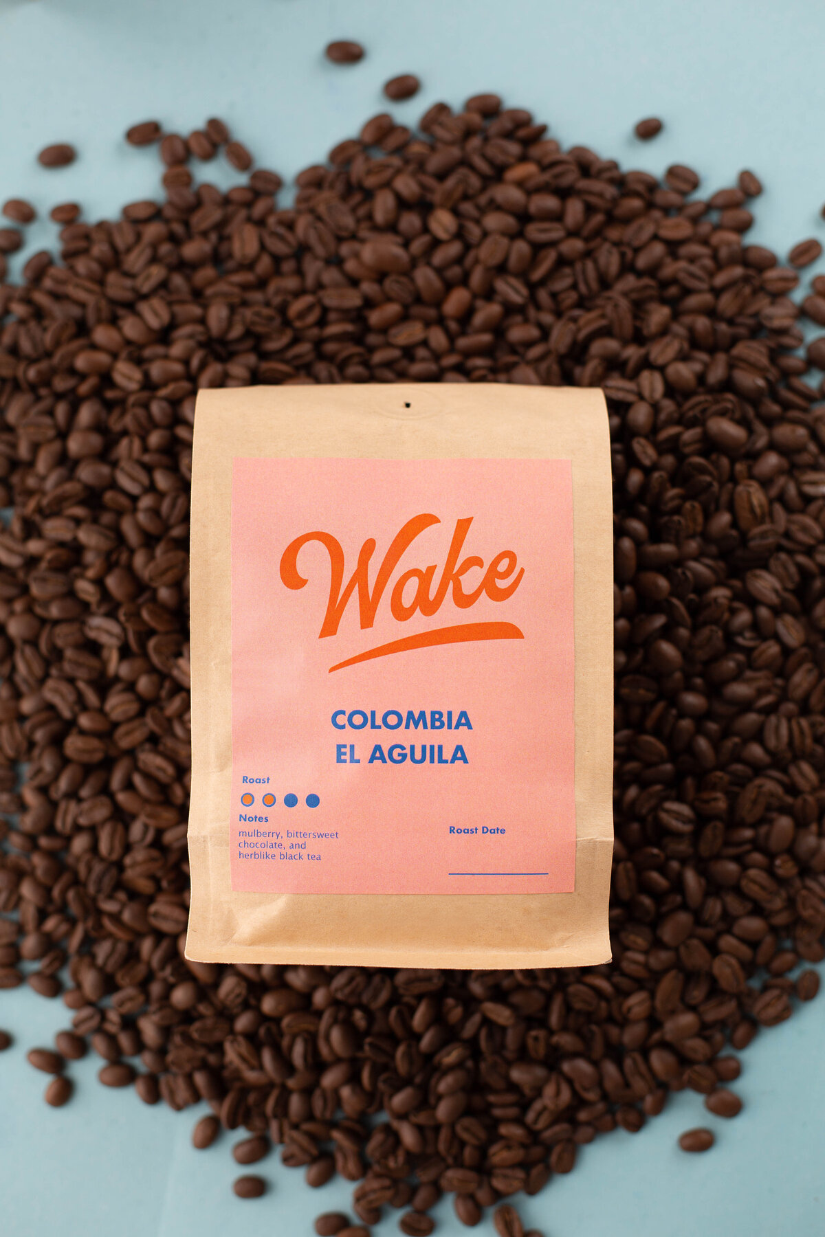 Branded bag of coffee beans, landing in a pile of loose coffee beans