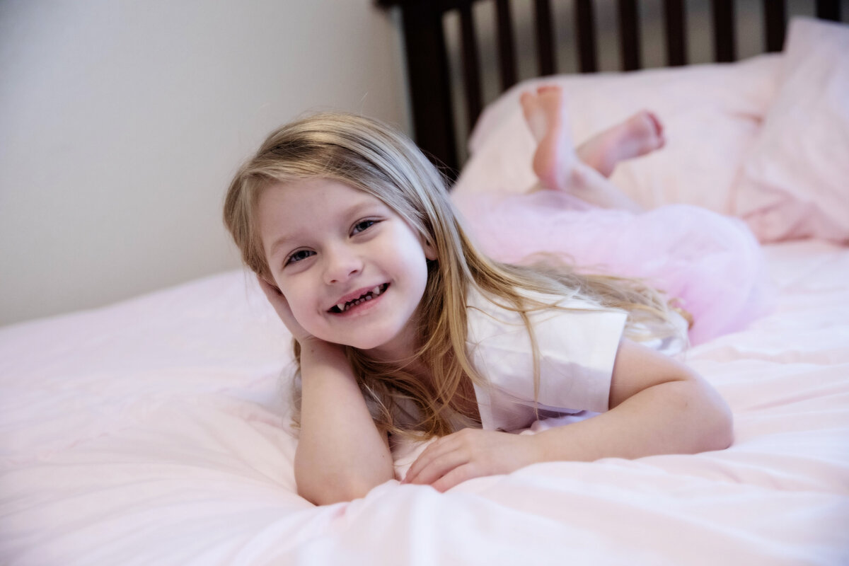 little girl portrait laying on bed