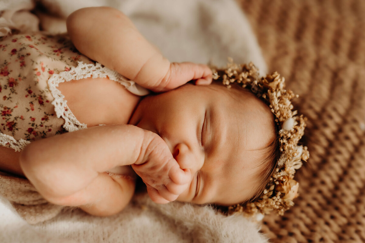 baby girl squishes face with her own hands
