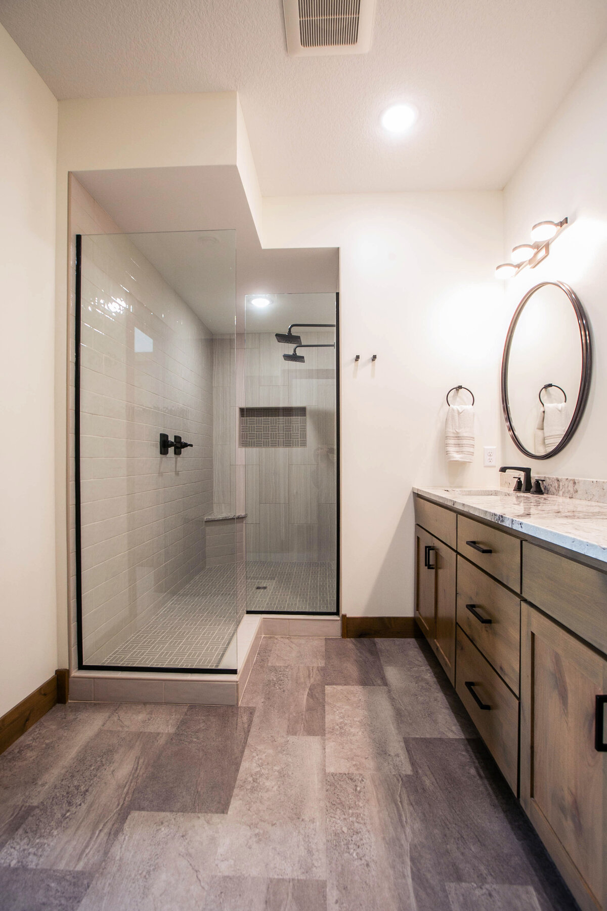 Custom bathroom with dark cabinets, double vanity, and walk-in shower in Elk River custom home