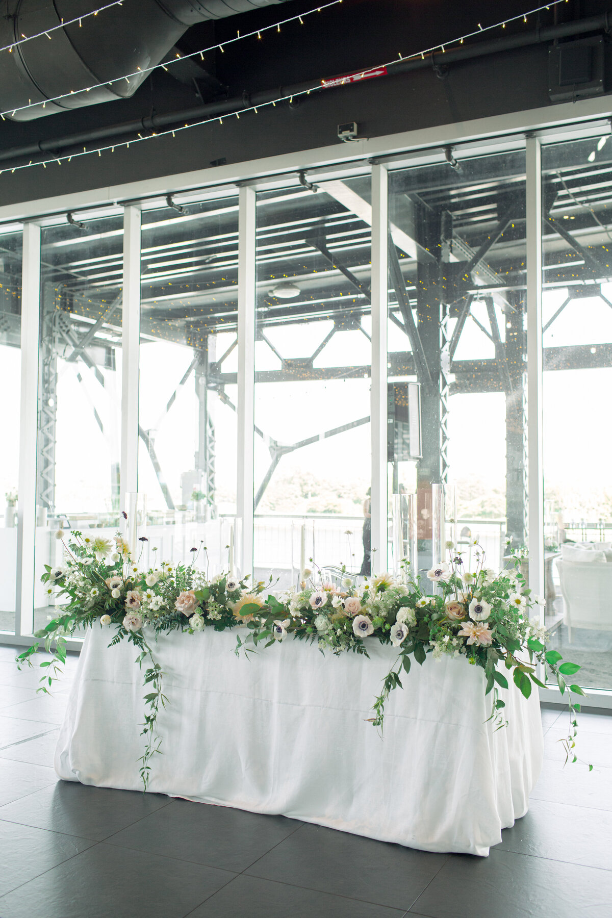 Lush green sweetheart flowers on a table at a bright Science Centre wedding reception.