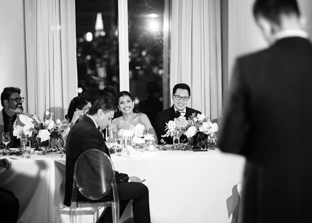 Bride and groom at their wedding reception listening to a speech at Public Hotel in NYC