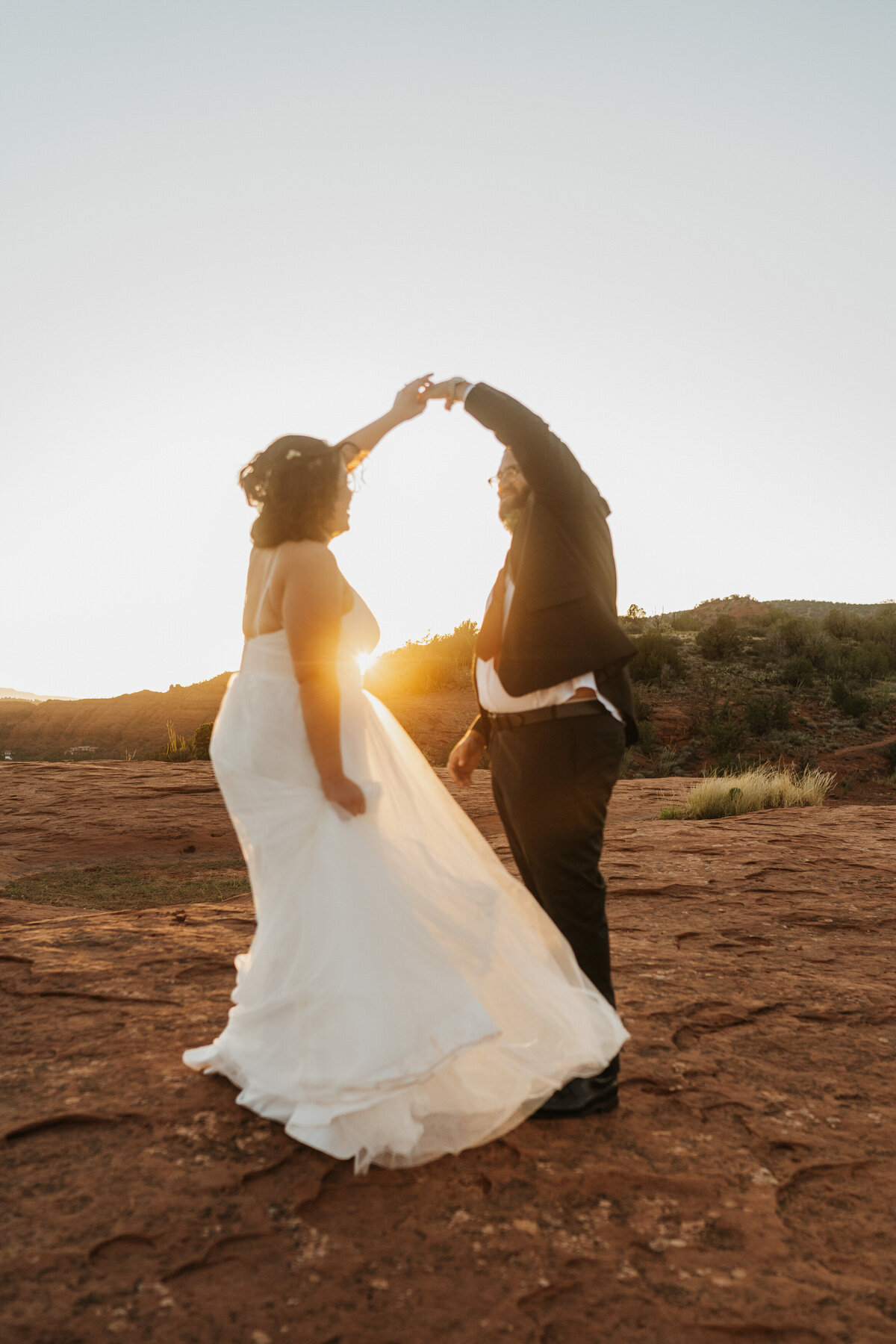 A wedding couple dancing in the desert 