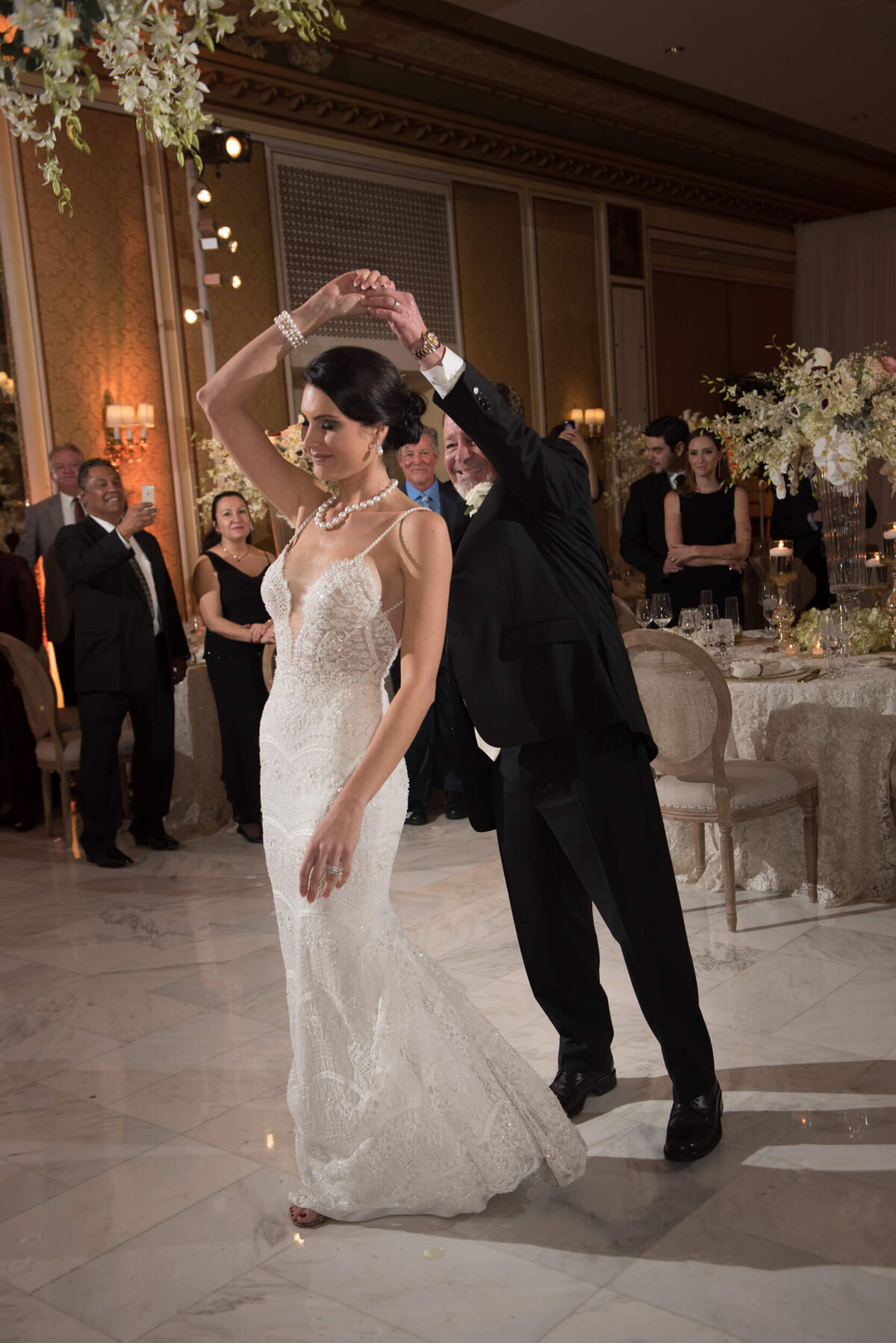 Groom twirls bride around during their first dance at the reception