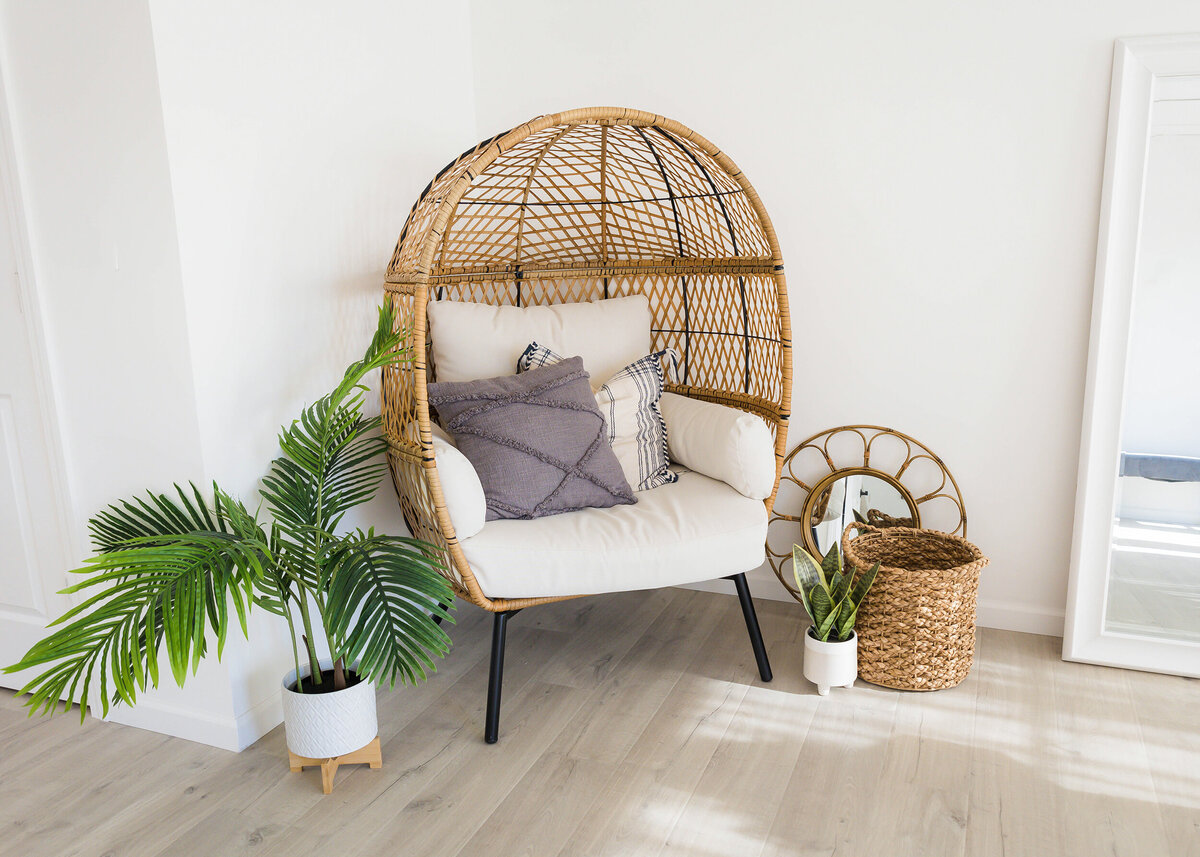 Egg chair surrounded by greenery and boho furniture
