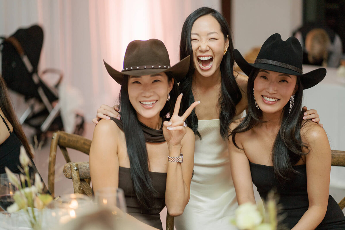 Guests at the Colorado Aspen Meadows Resort wedding reception pose together wearing cowboy hats with the bride.