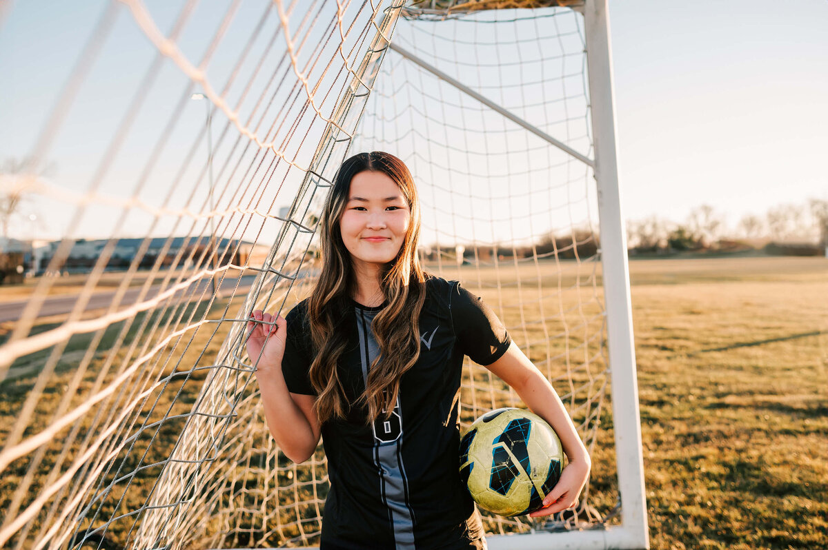 senior girl holding soccer ball at willard high school near Branson