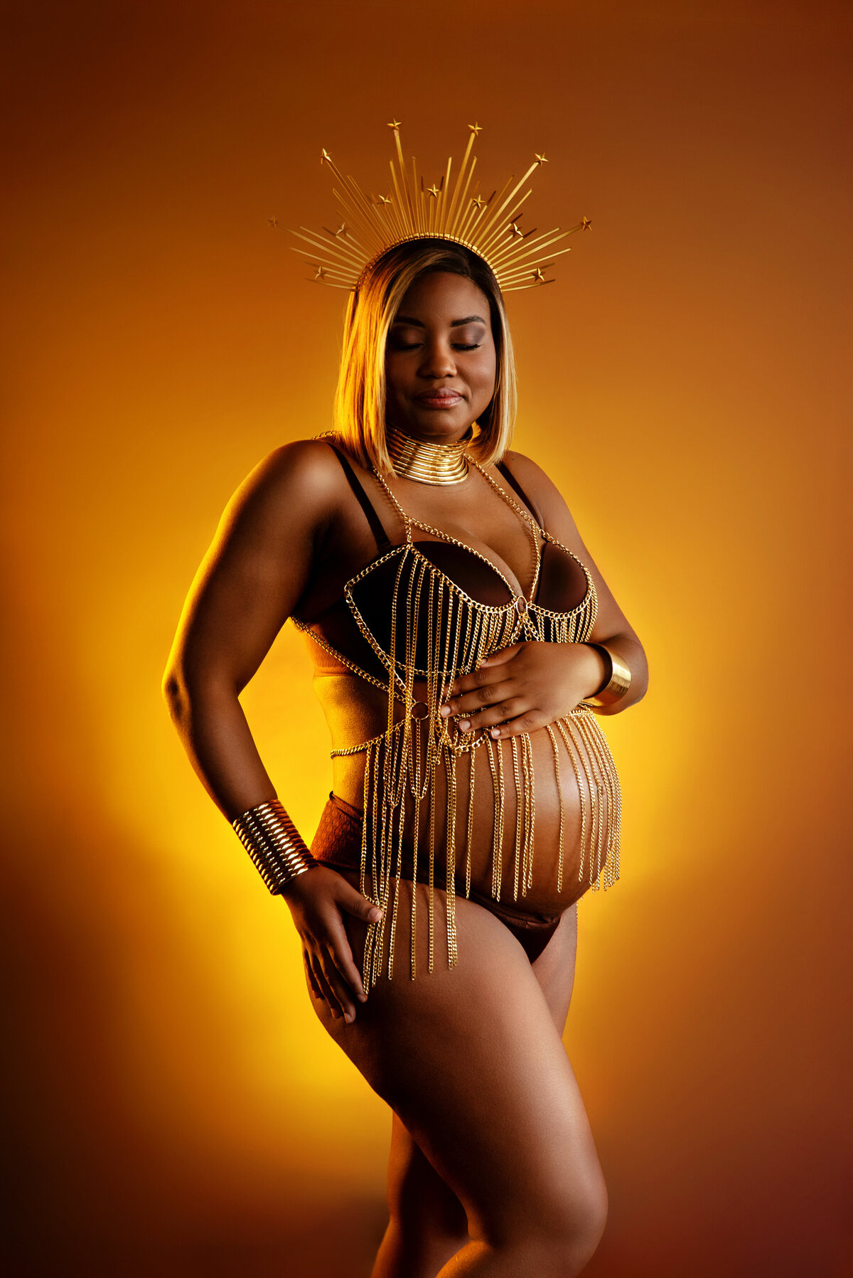 st-louis-maternity-photographer-glowing-pregnant-mom-in-gold-chains-crown-and-african-jewlery-with-gold-lighting