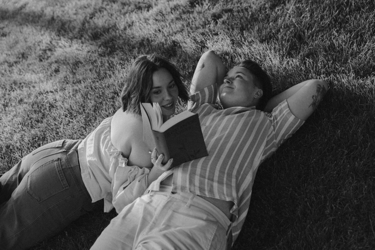 Romantic Couples Session Reading Together in the Grass During Golden Hour