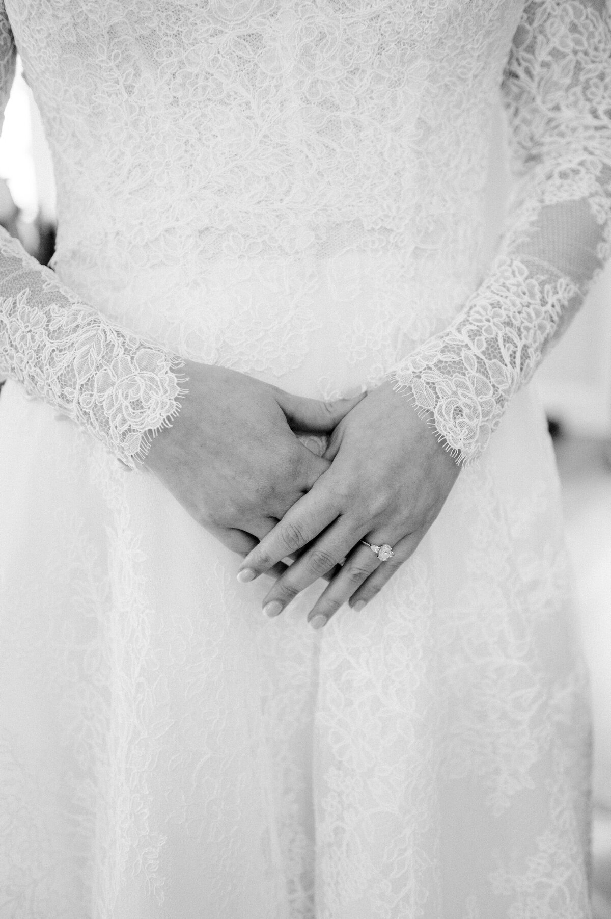 close up of a bride's hands resting on her wedding dress