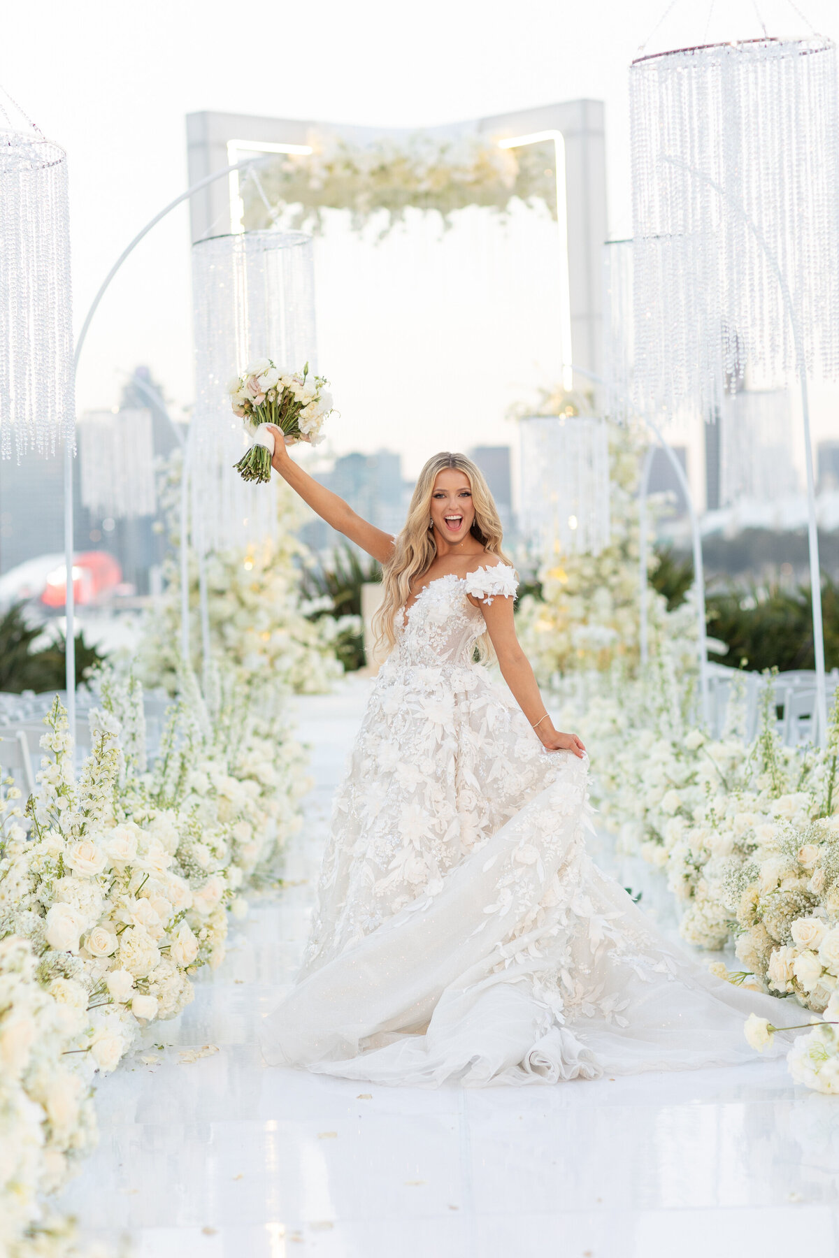 A bride holding her dress with one hand and a bouquet with the other