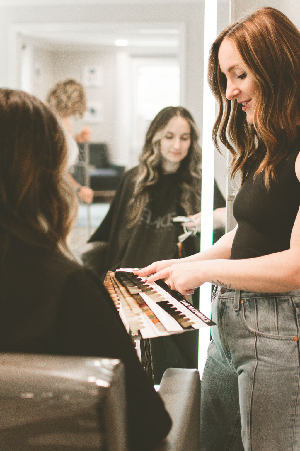 Hairstylist and client review and decide on color