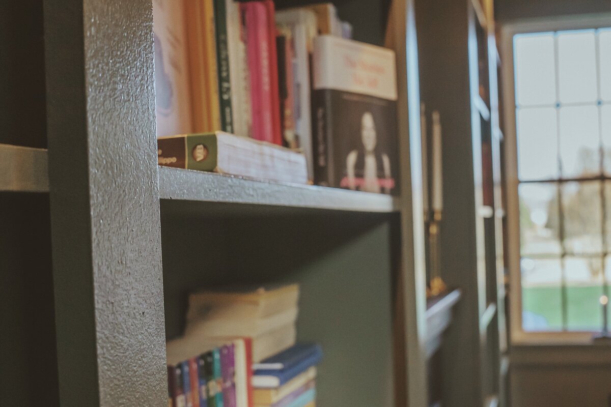 Built-in libary shelves side view filled with books and a view of the window