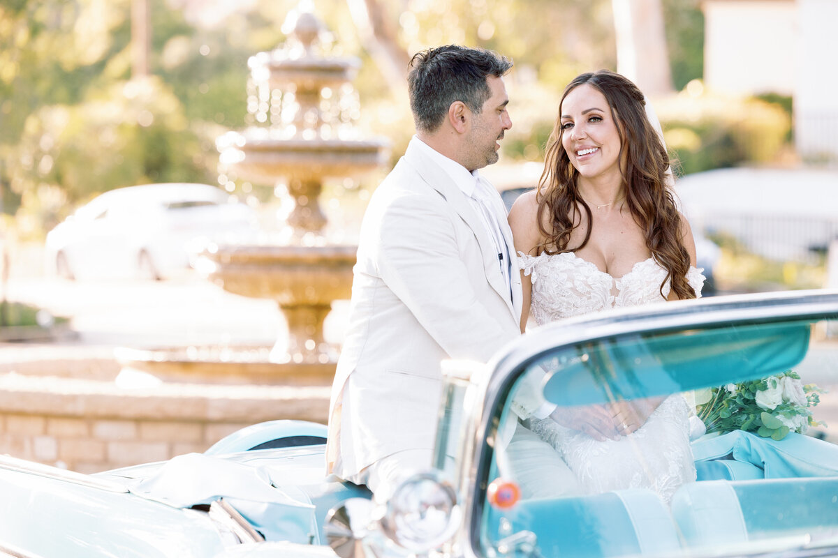 Couple sitting on a convertible blue car