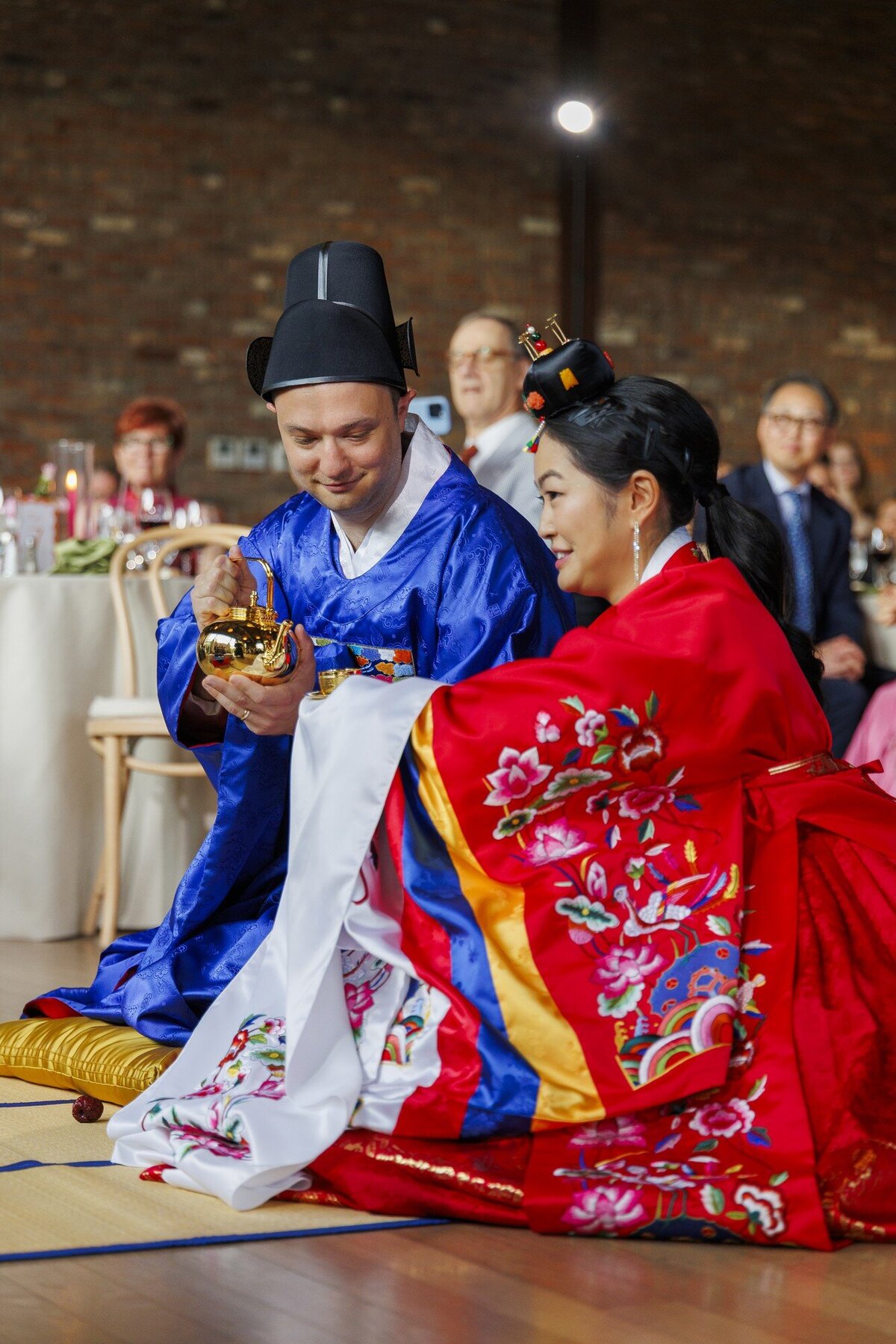 Couple in traditional Korean hanbok during a wedding tea ceremony