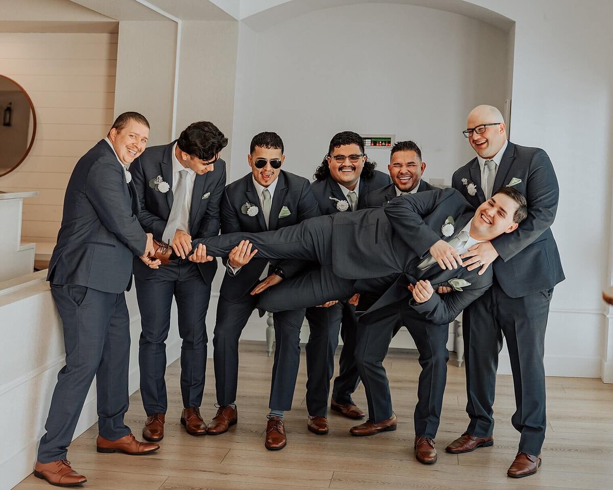 Colorado wedding photograph of groom being lifted up by groomsman
