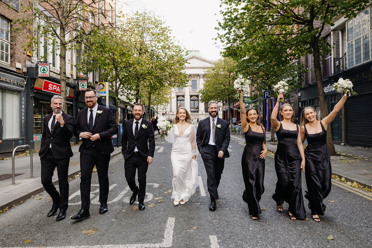 Bride and groom with their wedding party walking in the street in Dublin, Ireland