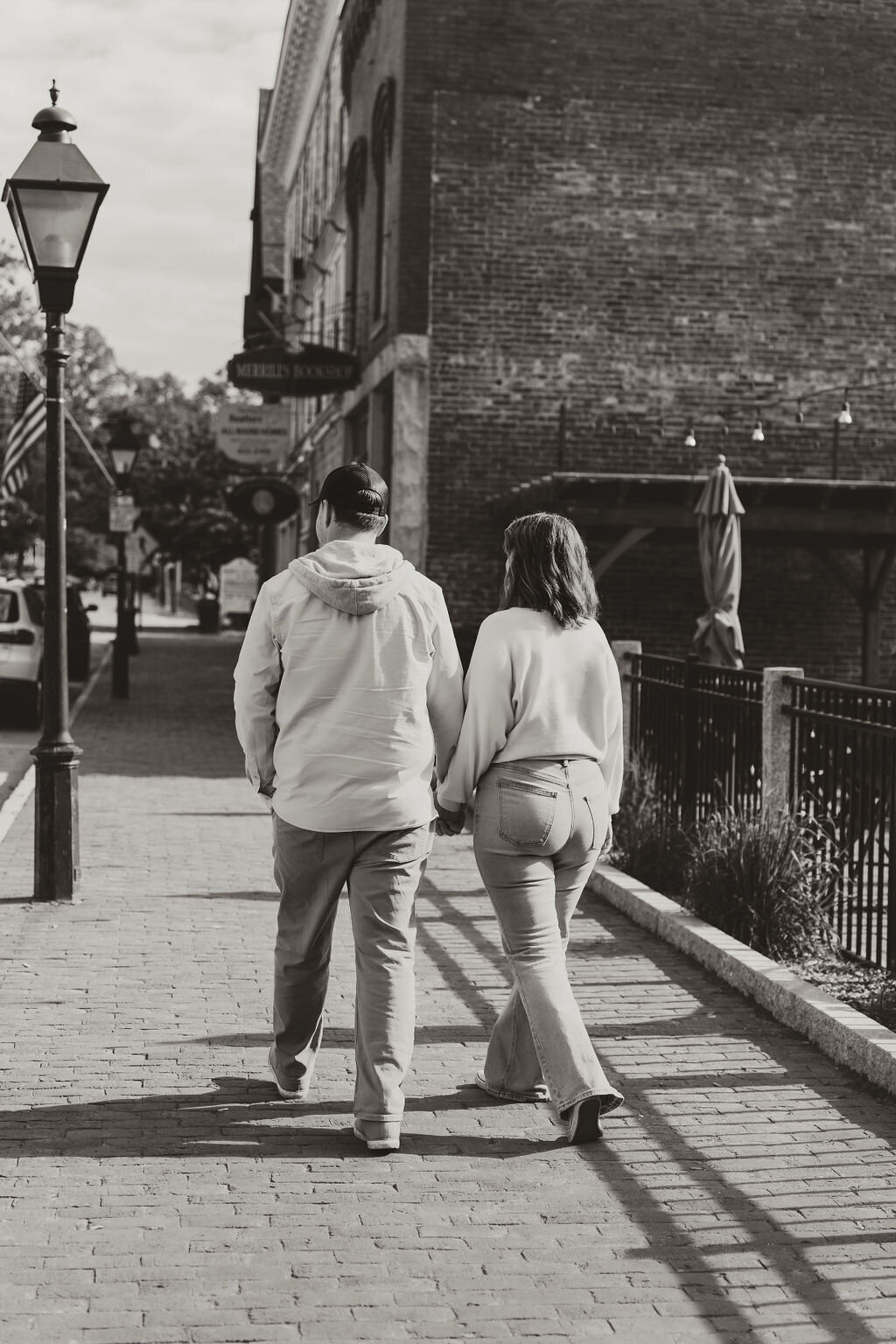 Photo of couple holding hands walking together downtown Central Maine