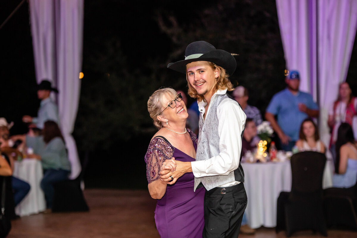 groom dances with mother in purple dress at wedding in New Braunfels Texas