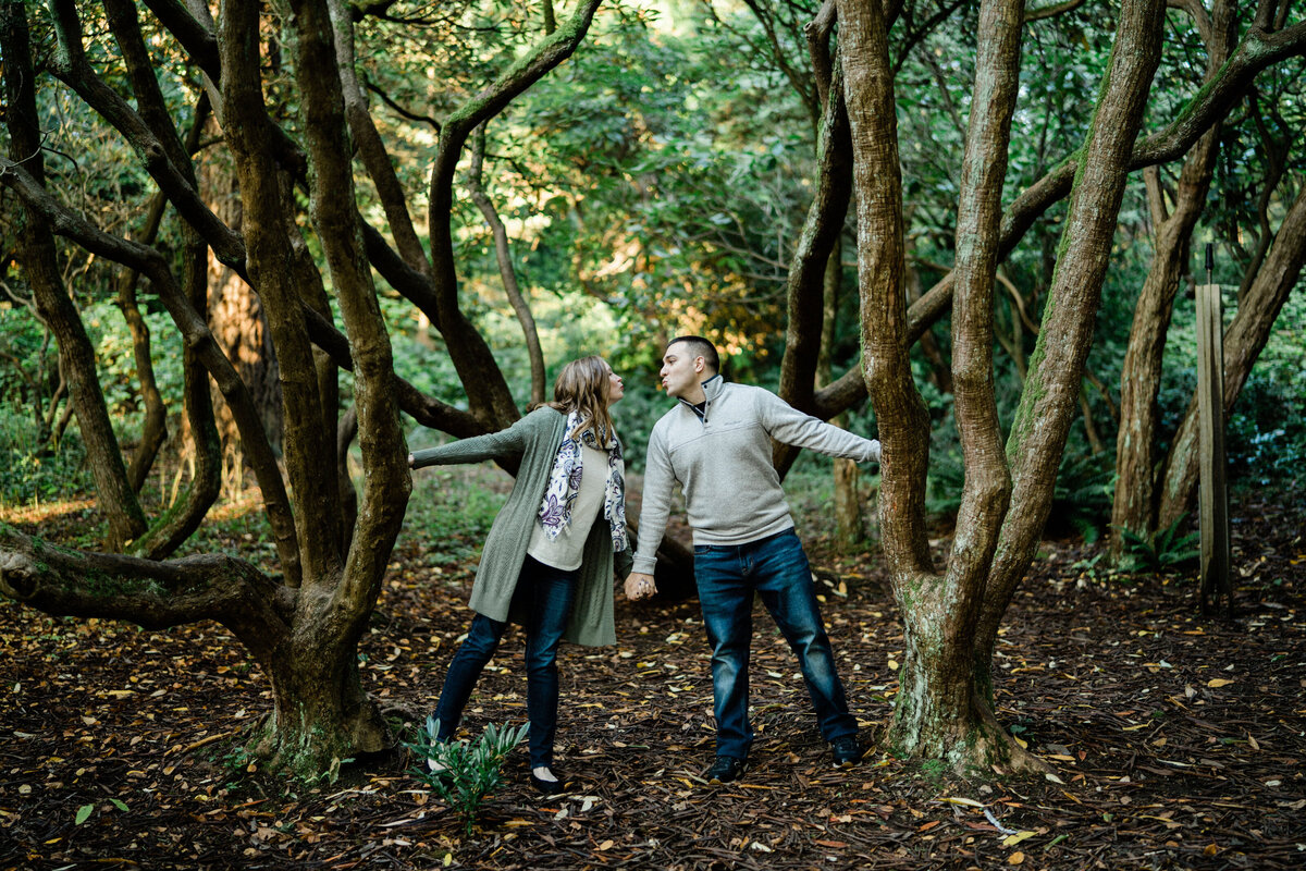 creative engagement photos in seattle at university of washington arboretum as coupe holds hands near large trees