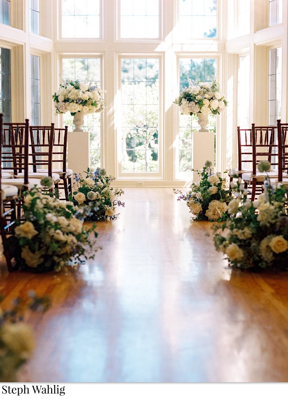 indoor ceremony, florist, urn arrangements, pedestals, blue, white, flowers, greenery, wedding ceremony