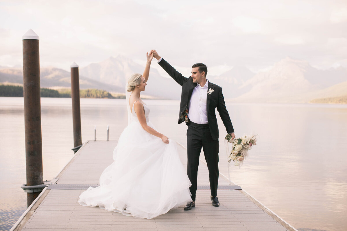 groom twirling bride on dock